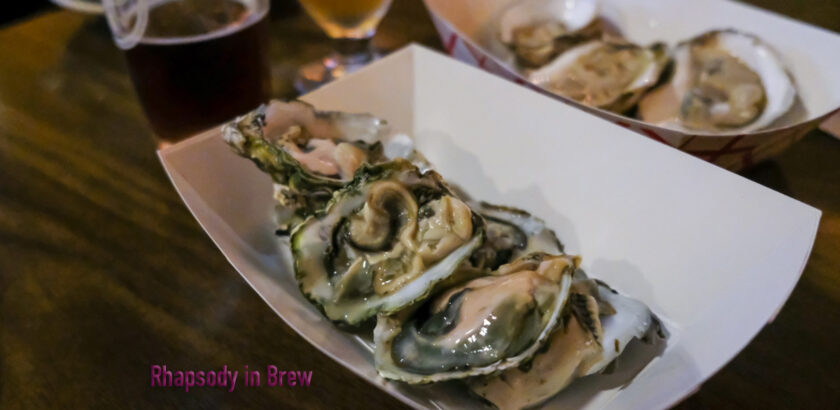 six oysters on the half shell in a paper container